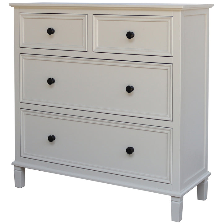 White dresser with four drawers and black knobs on a white background