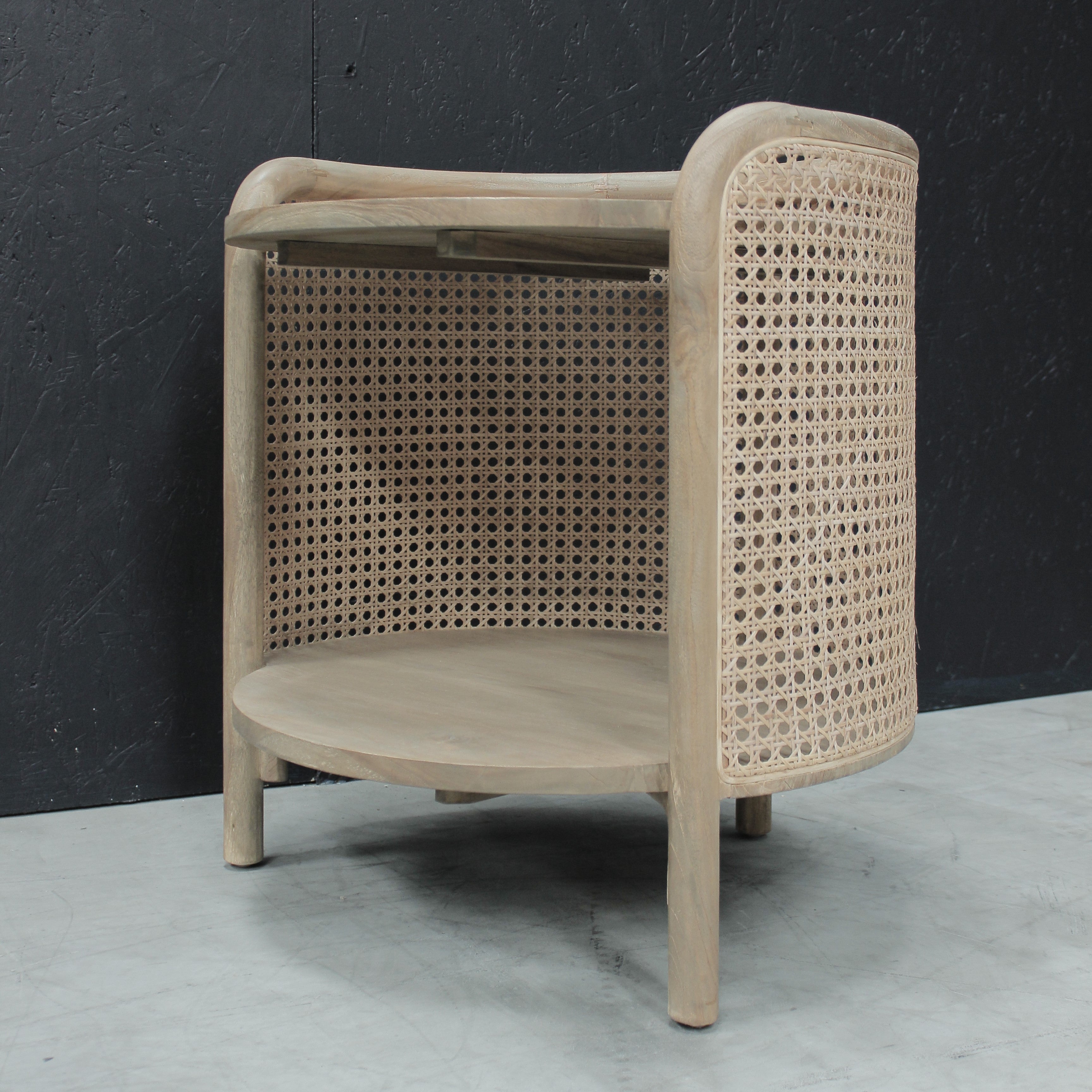 Wooden side table with rattan against a black background