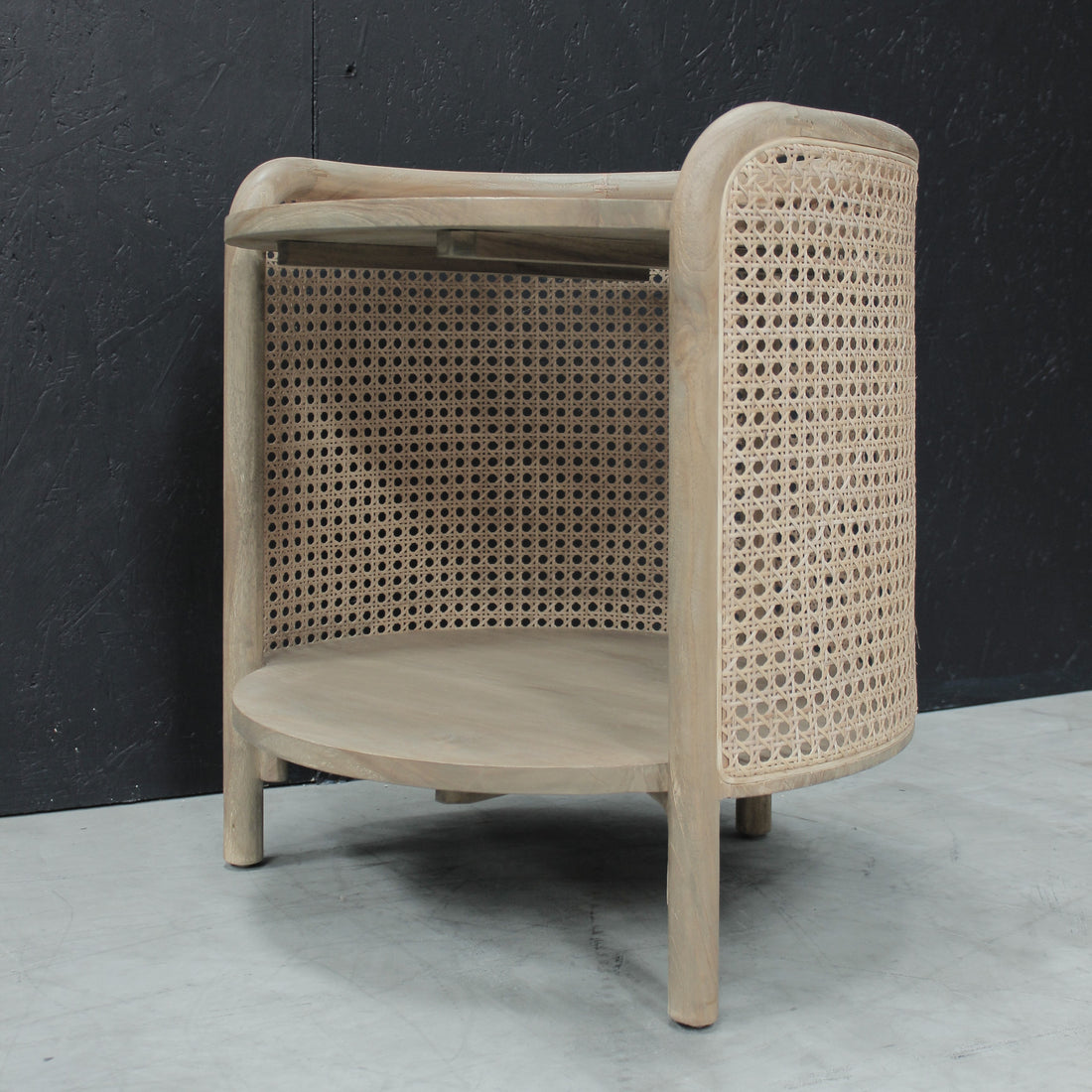 Wooden side table with rattan against a black background