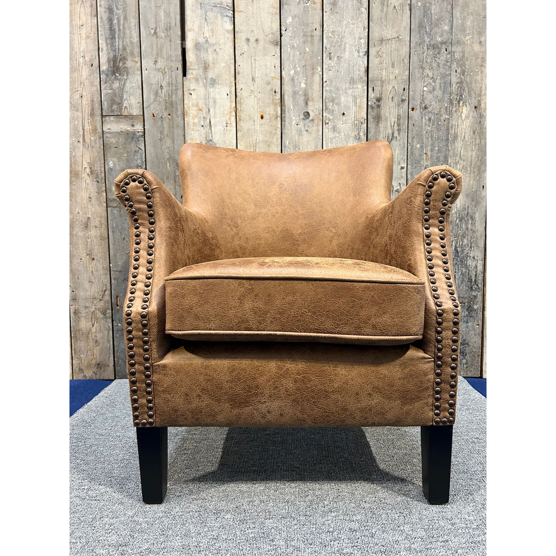 Havenheim Furniture Cromarty armchair in vegan vintage leather with plush cushioning and wooden legs, showcasing stylish comfort.