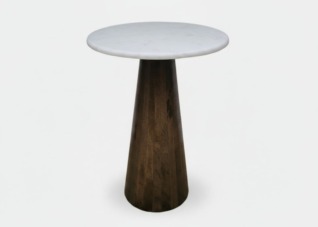 Small round table with a white marble  top and dark wooden cone-shaped base on a white background