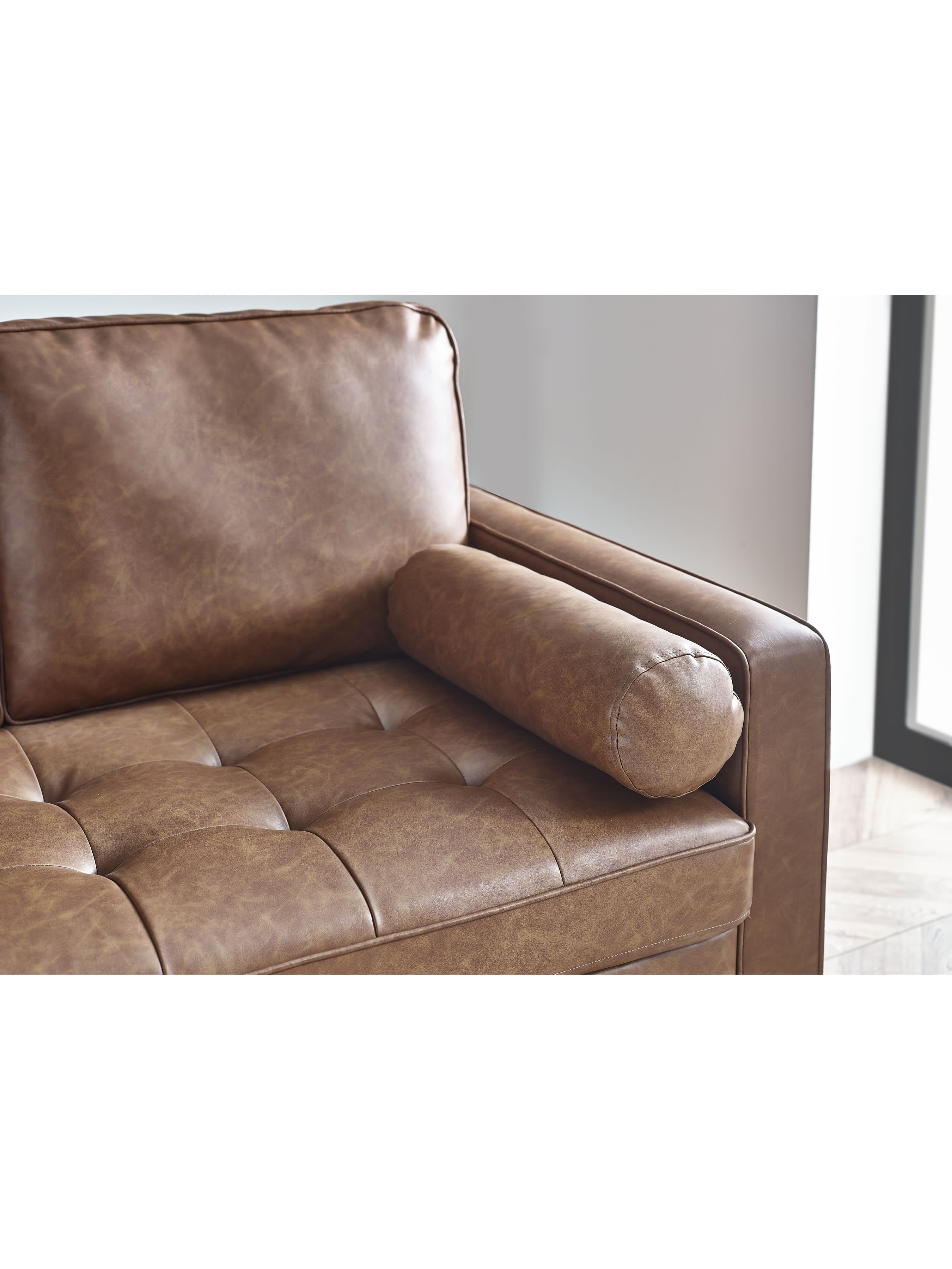 Close-up of Julian Bowen Henley 2-seater sofa in brown tan faux leather with bolster cushions, showcasing the textured upholstery.