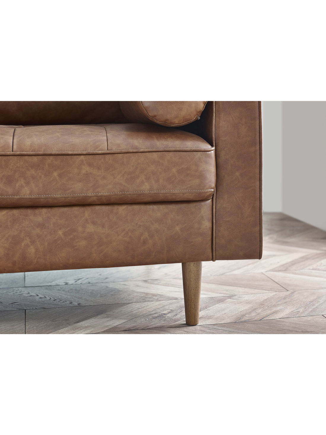 Close-up of Julian Bowen Henley 2 Seater sofa in brown tan faux leather with bolster cushions and wooden legs.