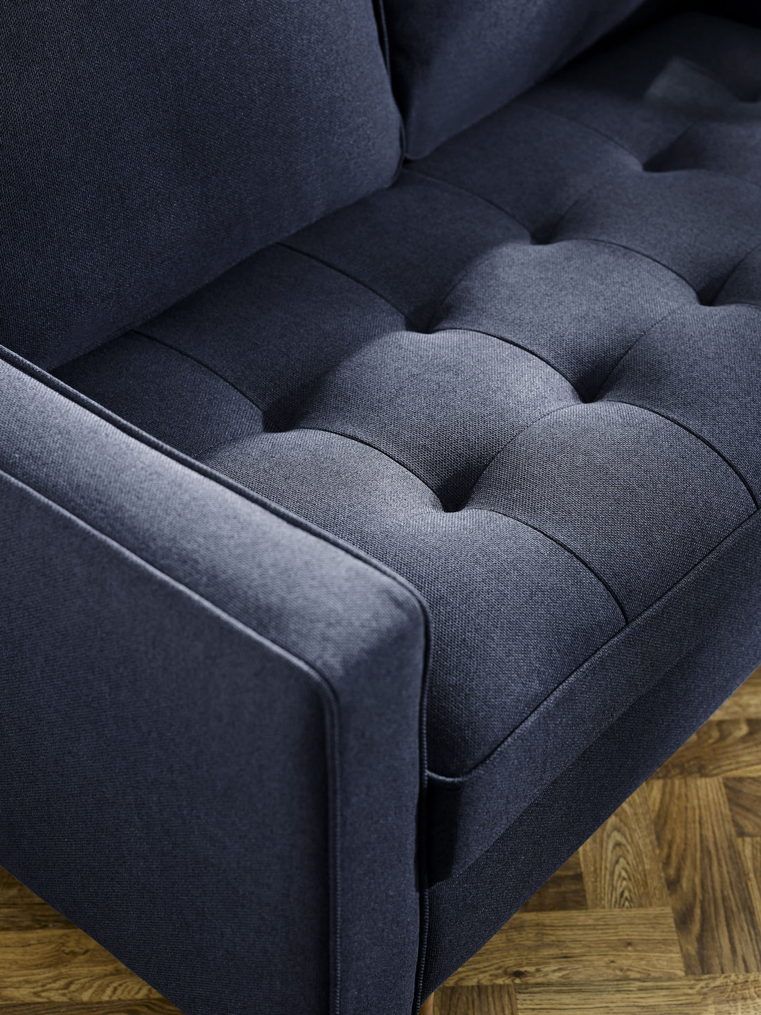 Close-up of Julian Bowen Henrietta deep blue linen upholstered 2-seater sofa, showcasing soft fabric and elegant design details.