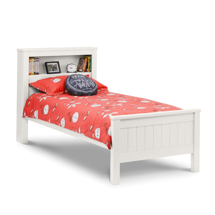 White bed with red bedding and a bookshelf headboard on a white background